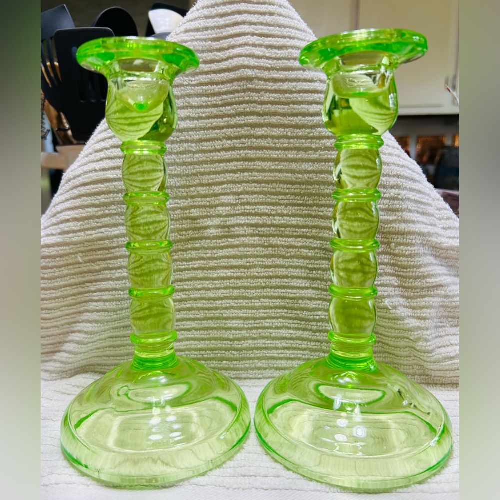 Antique vasoline glass candle stick holders, 8” tall by 4.25” wide at base.